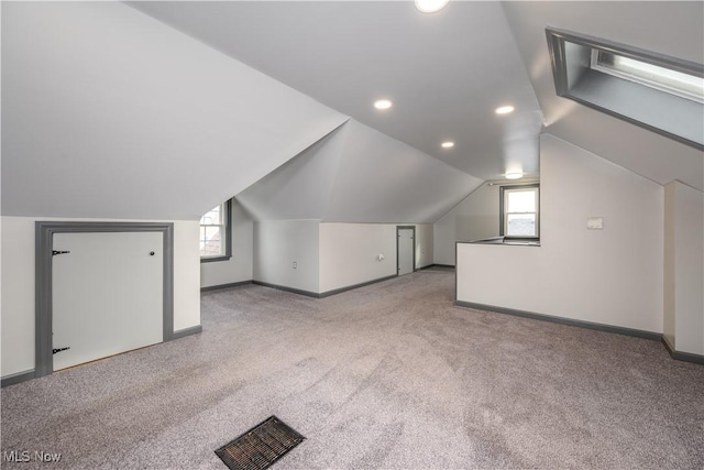 bonus room featuring vaulted ceiling and light colored carpet