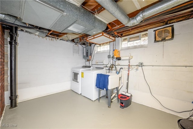 basement featuring sink, washing machine and clothes dryer, and electric panel