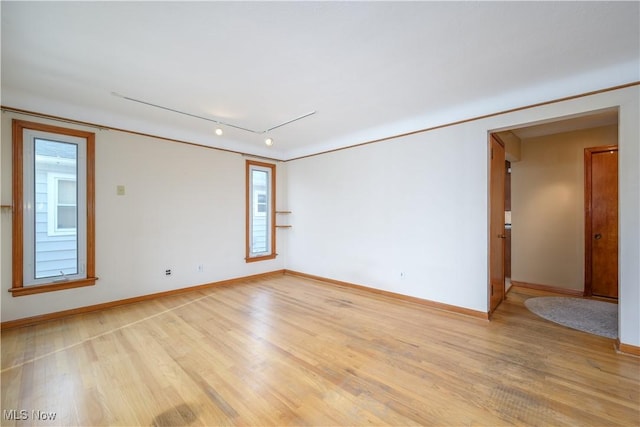 spare room with track lighting and light hardwood / wood-style flooring