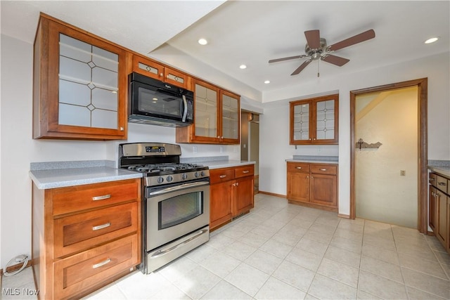 kitchen with gas range, light tile patterned floors, and ceiling fan