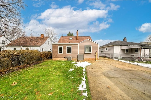 back of house featuring a yard and central AC unit