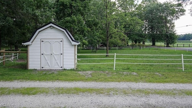 view of outdoor structure with a rural view and a lawn