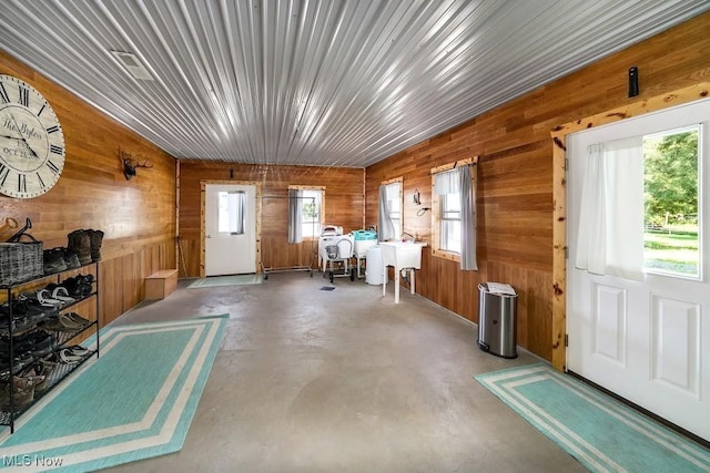 miscellaneous room featuring wooden walls and concrete floors