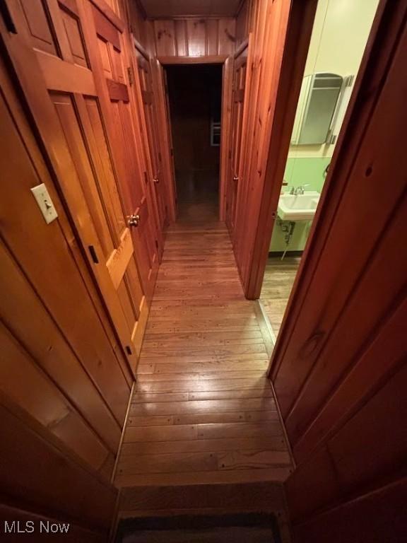 hallway with wooden walls and light wood-type flooring