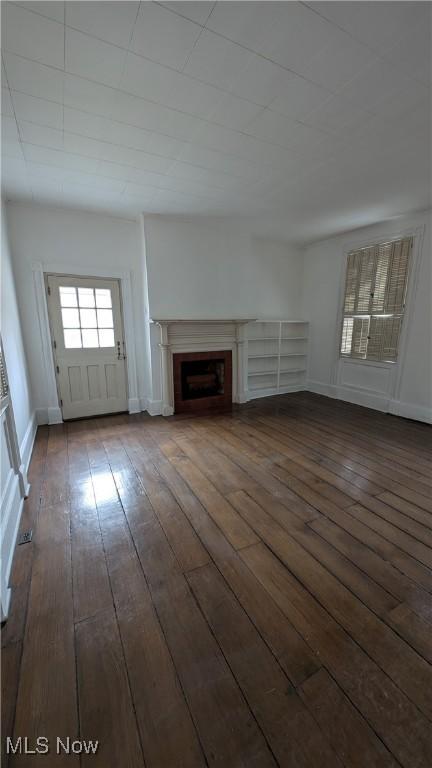 unfurnished living room with dark wood-type flooring