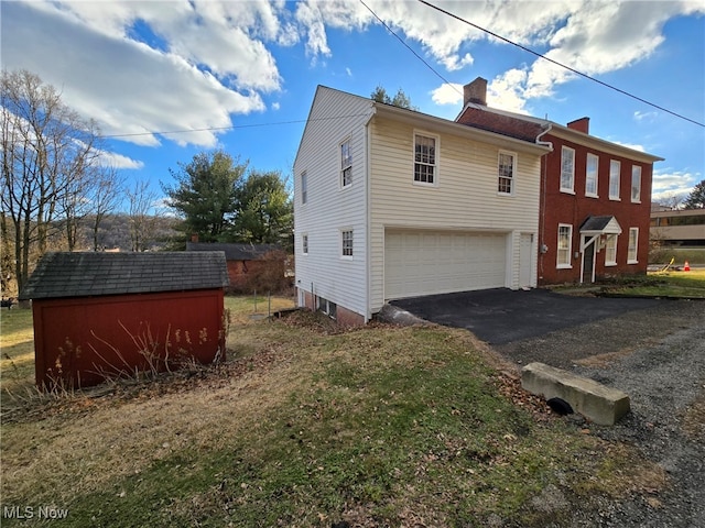 exterior space with a garage and a lawn