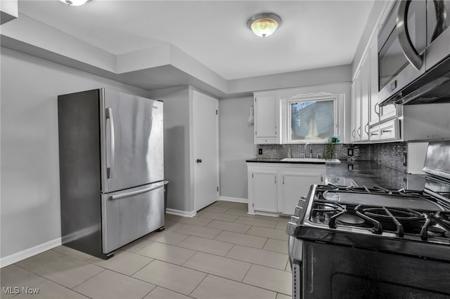 kitchen featuring appliances with stainless steel finishes, sink, decorative backsplash, and white cabinets