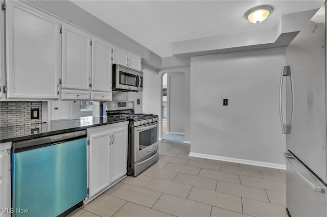 kitchen with white cabinetry, backsplash, stainless steel appliances, and light tile patterned flooring