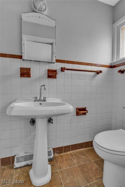 bathroom with tile walls, tile patterned floors, and toilet