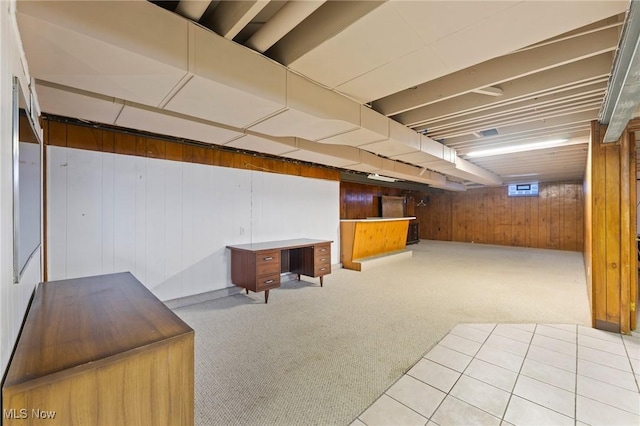 basement featuring wooden walls and light carpet