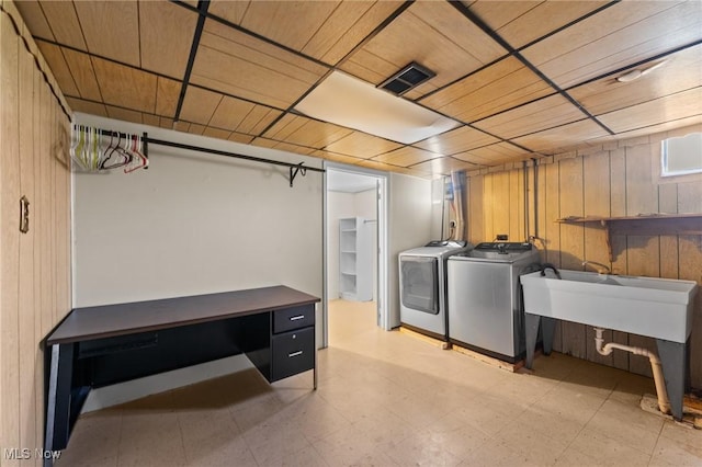 laundry room with wood ceiling, independent washer and dryer, and wood walls