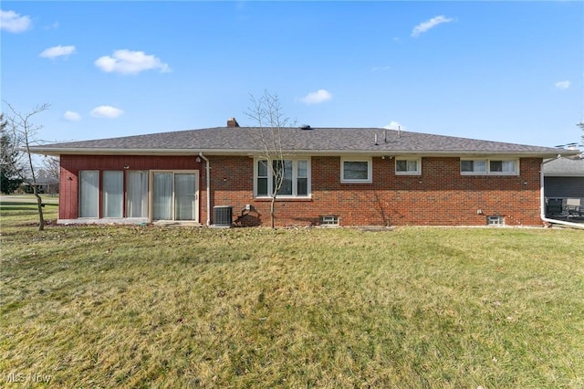 back of property featuring central AC unit and a lawn