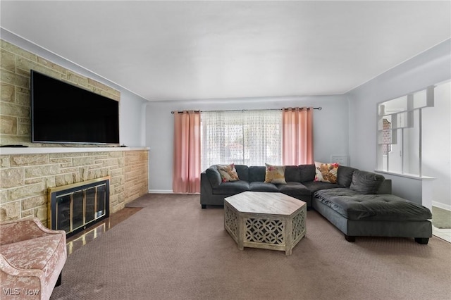 carpeted living room with a stone fireplace