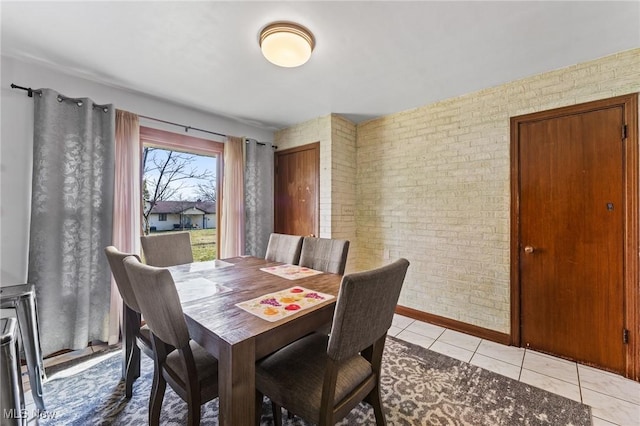 tiled dining space featuring brick wall