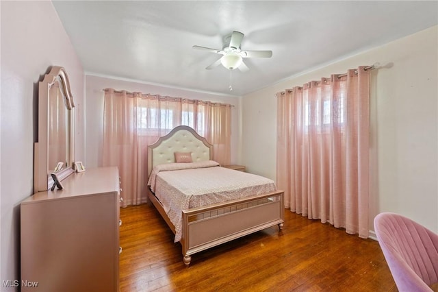 bedroom with dark hardwood / wood-style flooring and ceiling fan