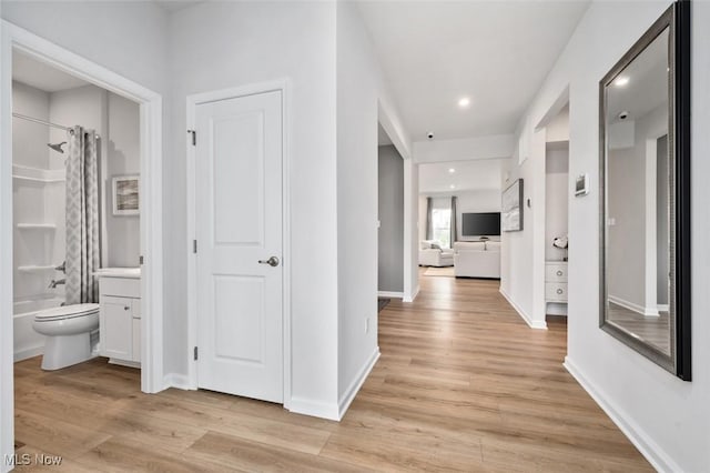 hallway with light hardwood / wood-style floors