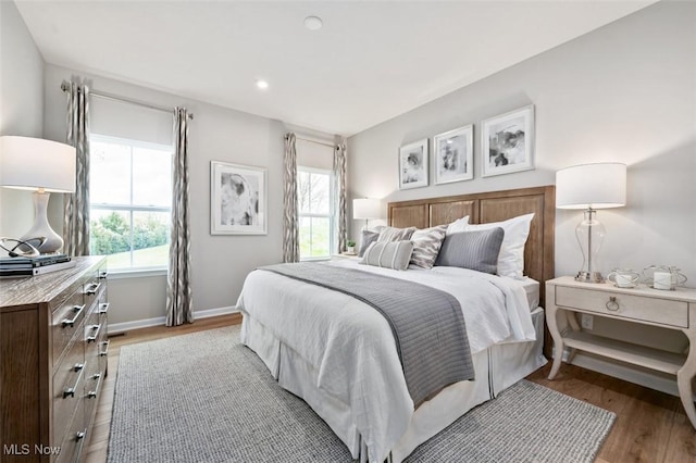 bedroom with wood-type flooring and multiple windows