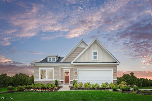 craftsman house featuring a garage and a yard