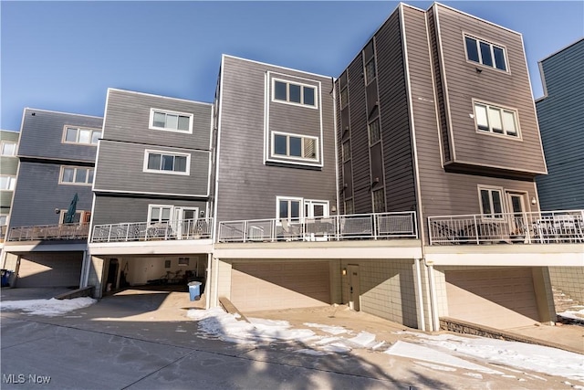 back of property featuring a garage and a balcony