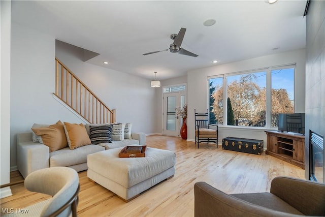 living room featuring ceiling fan and light wood-type flooring