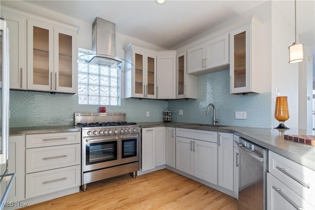 kitchen with extractor fan, pendant lighting, sink, stainless steel appliances, and light wood-type flooring