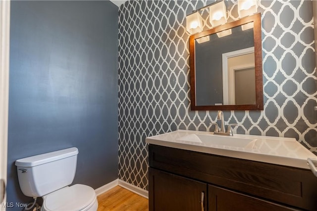 bathroom featuring vanity, hardwood / wood-style floors, and toilet