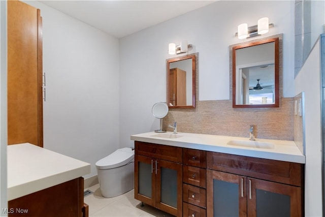 bathroom with tasteful backsplash, vanity, tile patterned floors, and toilet