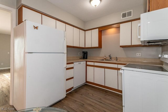 kitchen with white cabinetry, white appliances, dark hardwood / wood-style flooring, and sink