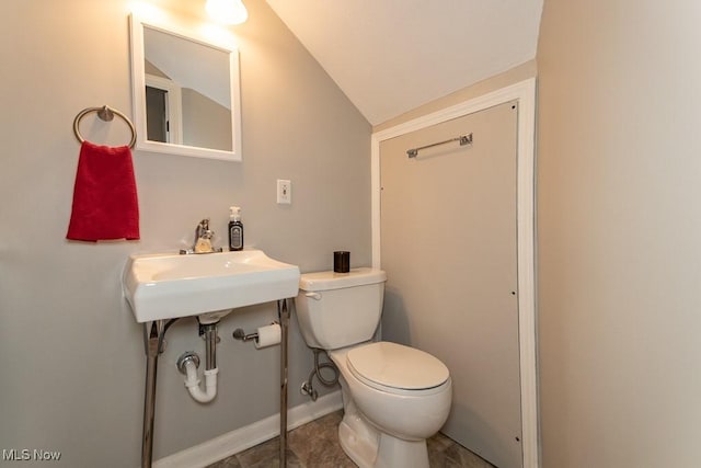 bathroom featuring sink, vaulted ceiling, and toilet