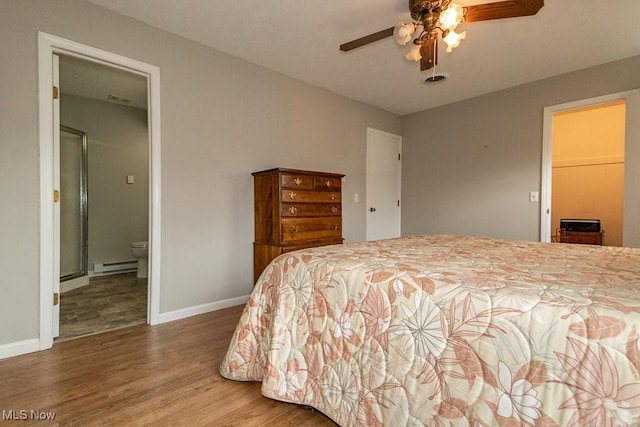 bedroom featuring a baseboard radiator, hardwood / wood-style floors, ceiling fan, and ensuite bath