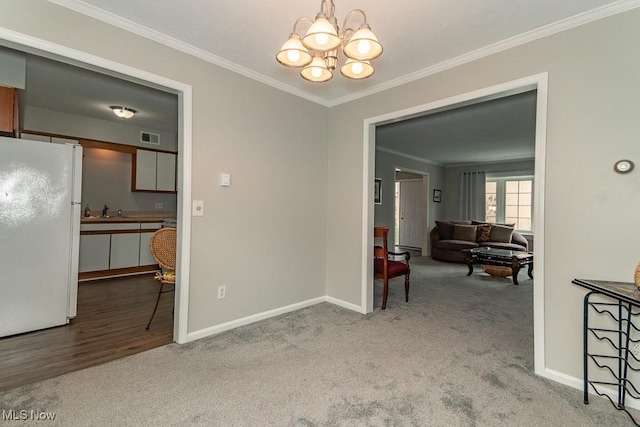 dining space featuring crown molding, sink, light carpet, and an inviting chandelier