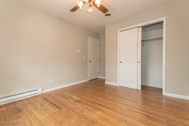 unfurnished bedroom with a closet, ceiling fan, light hardwood / wood-style floors, and baseboard heating