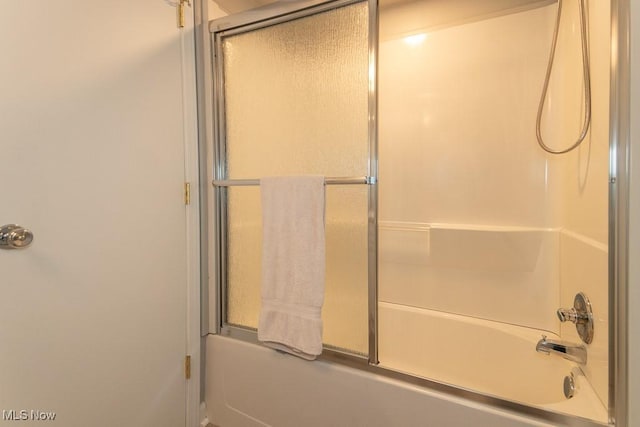 bathroom featuring bath / shower combo with glass door