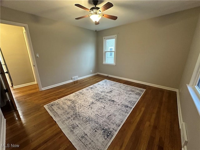 spare room with dark hardwood / wood-style floors and ceiling fan