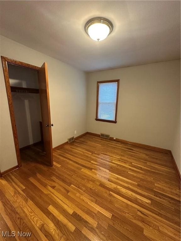 unfurnished bedroom featuring hardwood / wood-style floors and a closet