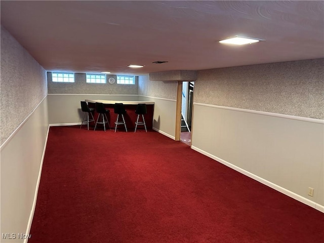 basement with carpet flooring and bar area