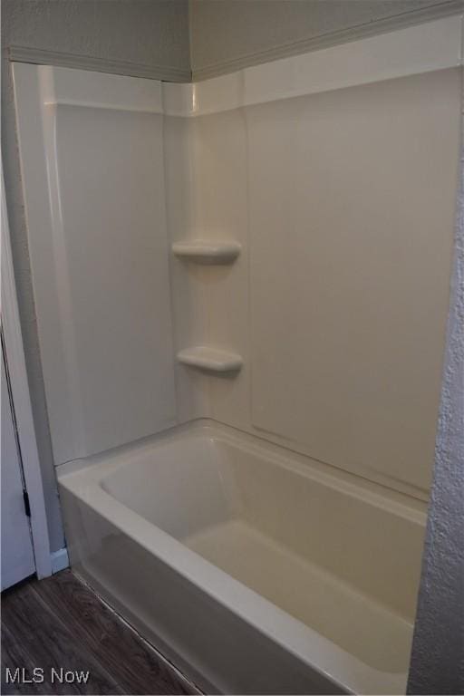 bathroom featuring wood-type flooring and bathing tub / shower combination