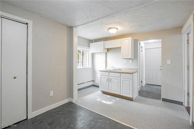 kitchen featuring white cabinetry, sink, and a textured ceiling