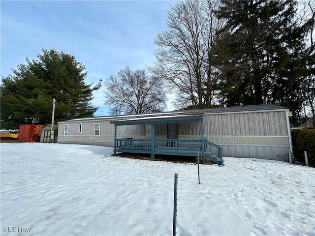 view of snow covered back of property