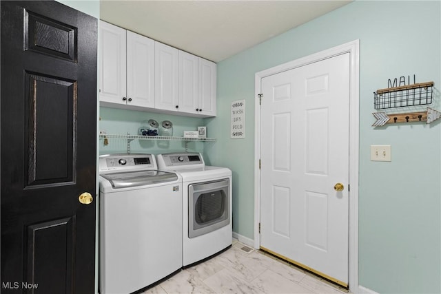 washroom with cabinets and washer and clothes dryer