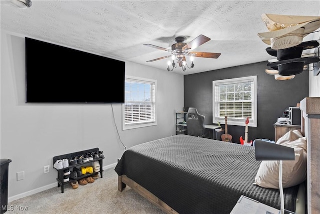 carpeted bedroom featuring multiple windows, ceiling fan, and a textured ceiling