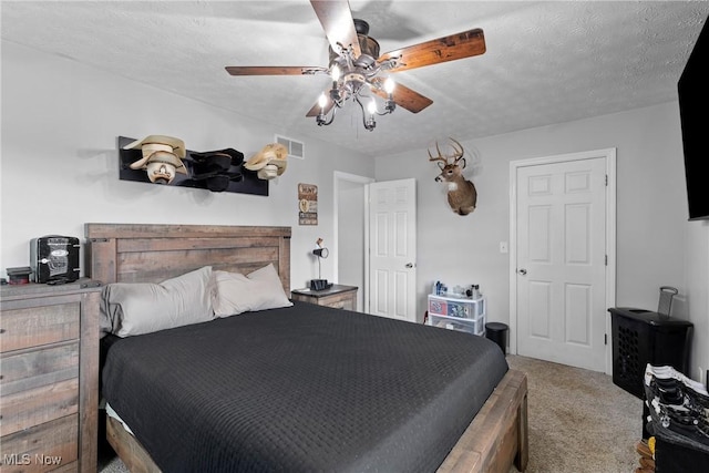 carpeted bedroom with ceiling fan and a textured ceiling