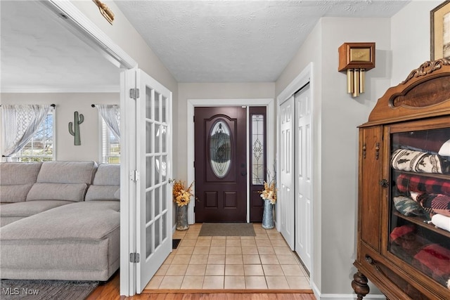 entrance foyer featuring light tile patterned floors and a textured ceiling