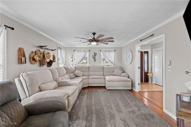 living room featuring hardwood / wood-style floors, ornamental molding, and ceiling fan