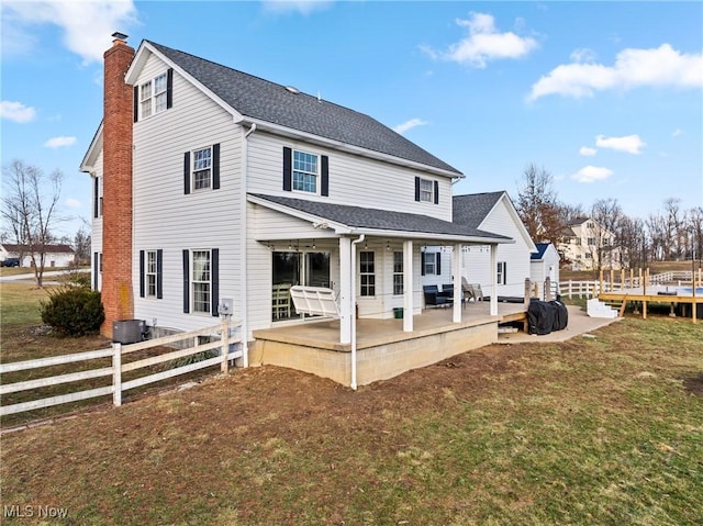 rear view of property featuring a yard, a trampoline, and a patio area