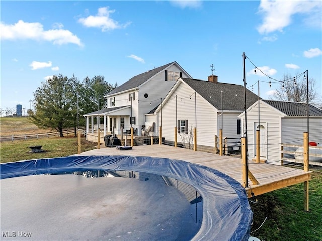 rear view of property featuring a pool side deck