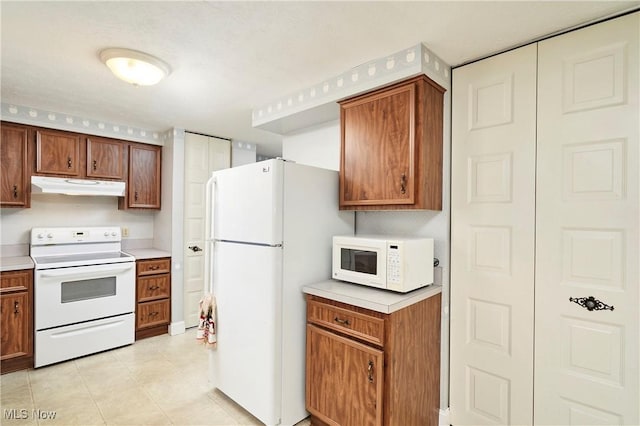 kitchen with light tile patterned floors and white appliances