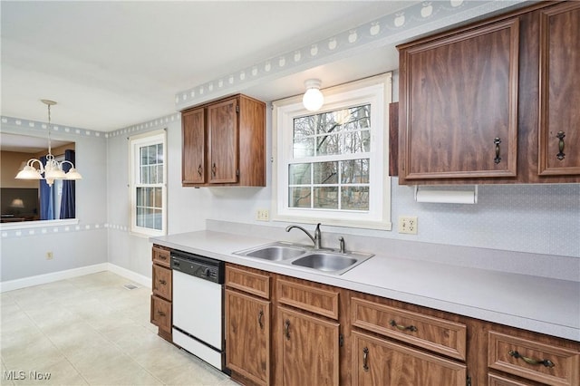 kitchen with sink, dishwasher, an inviting chandelier, backsplash, and decorative light fixtures