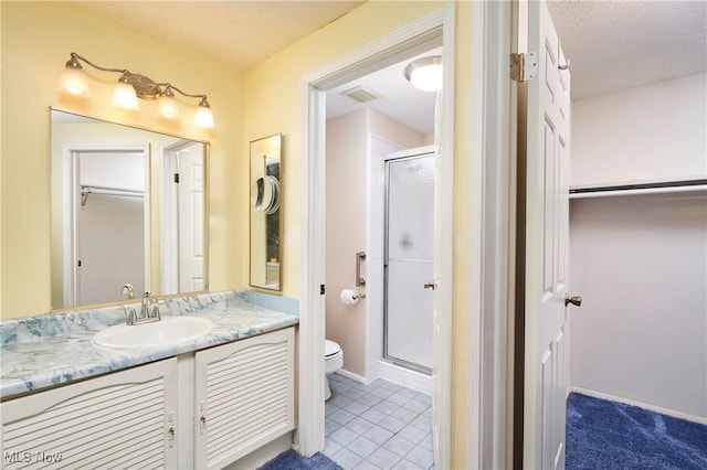 bathroom featuring vanity, toilet, an enclosed shower, and tile patterned flooring