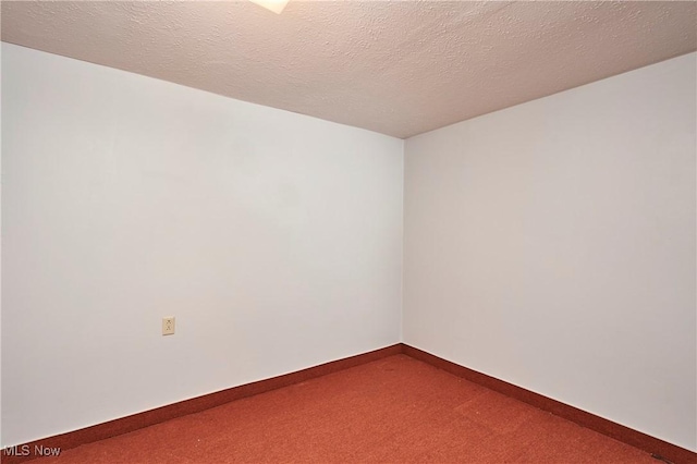 spare room featuring a textured ceiling and carpet flooring